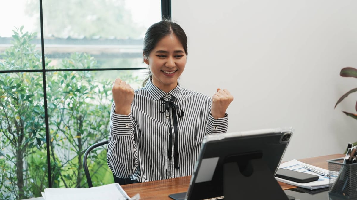 Successful investor celebrating positive financial growth on a digital tablet.