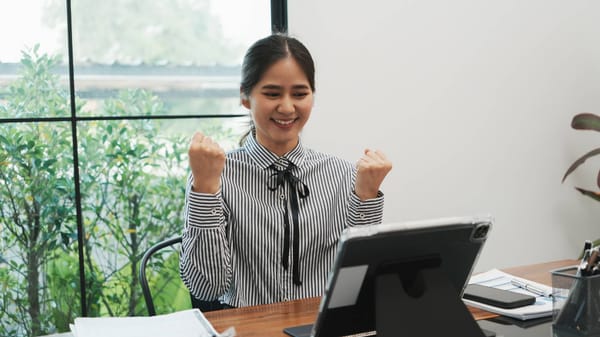 Successful investor celebrating positive financial growth on a digital tablet.