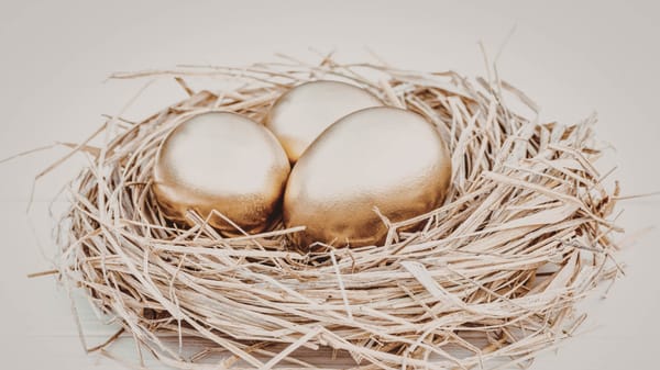Three golden eggs resting in a bird's nest representing a secure retirement nest egg.